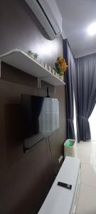 a room with a tv on a wall at Sarrah Homestay At Kasa Height Residence in Kampong Alor Gajah