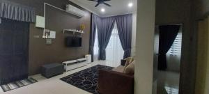 un soggiorno con divano e TV di Sarrah Homestay At Kasa Height Residence a Kampong Alor Gajah