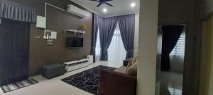a living room with a couch and a tv at Sarrah Homestay At Kasa Height Residence in Kampong Alor Gajah
