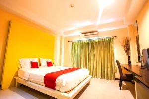 a bedroom with a bed and a desk and a window at The Main Event in Pattaya South