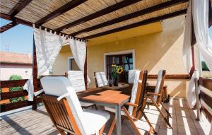 a patio with a wooden table and chairs on a deck at Nice Home In Velika With Outdoor Swimming Pool in Velika