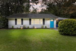 a white house with a blue door and a yard at Palmetto House of Charleston in Charleston