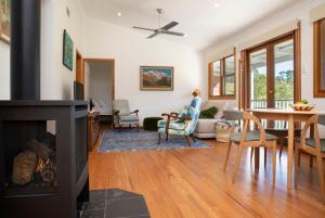 a living room with a fireplace and a dining room at The Artists Retreat in Bilpin