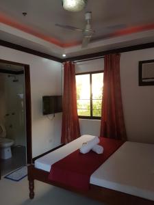 a bedroom with a bed and a window and a toilet at JACE'S Travelers Inn in El Nido