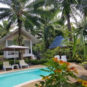 une villa avec une piscine et des palmiers dans l'établissement Groovy Bungalows, à Ao Nang Beach