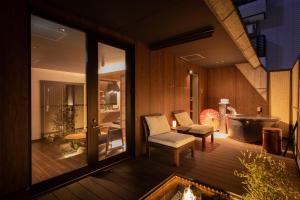a room with a tub and a chair on a deck at Dotonbori no Yado Konjakuso - Vacation STAY 26587v in Osaka