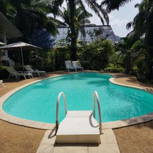- une piscine avec un banc dans un complexe dans l'établissement Groovy Bungalows, à Ao Nang Beach