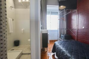 a bedroom with a bed and a bathroom with a tub at V Dinastia in Lisbon