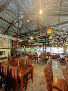 comedor con mesas y sillas de madera en Rock and Wreck Dive Resort en Tanjungbinga