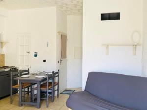 Habitación con mesa, sillas y cocina. en Appartement Lumio, 1 pièce, 2 personnes - FR-1-63-322, en Lumio