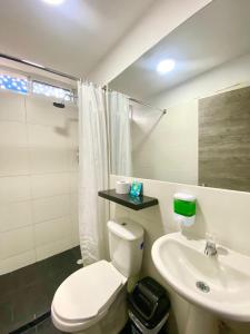 uma casa de banho com um WC branco e um lavatório. em Hotel Anauco em Bucaramanga