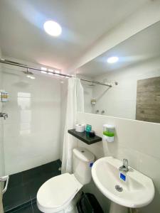 a bathroom with a white toilet and a sink at Hotel Anauco in Bucaramanga +84 photos