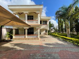a house with a brick walkway in front of it at Mudzini gardens - Luxury villa with a pool in Mombasa