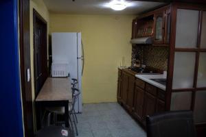 a kitchen with a white refrigerator and a counter at Linda casa azul ubicada en el corazón de Pátzcuaro in Pátzcuaro