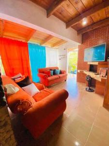 a living room with two couches and a tv at Primavera en Jarabacoa-contacto con la naturaleza in Jarabacoa