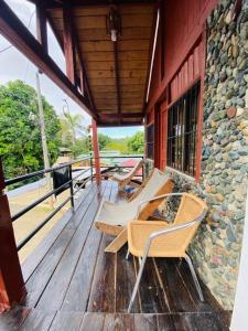a porch with several chairs on a wooden deck at Primavera en Jarabacoa-contacto con la naturaleza in Jarabacoa