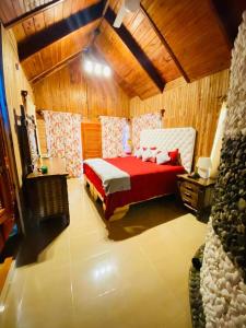 a bedroom with a red bed in a wooden room at Primavera en Jarabacoa-contacto con la naturaleza in Jarabacoa