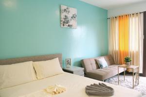 a bedroom with a large bed and a couch at Casa D’ Hiyas Homestay Panglao, Bohol in Panglao