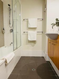 a bathroom with a shower and a sink and a shower at Cosy Apartment at Sebel Twin Waters Resort w Private Garden - 2 Mins Walk to Beach & River in Mudjimba