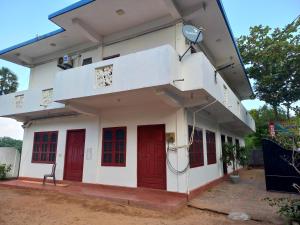 een gebouw met rode deuren en rode ramen bij Sayura Guest House in Trincomalee