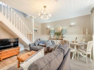 ein Wohnzimmer mit einem Sofa und einem TV in der Unterkunft Norfolk Cottages - The Ostlery in Smallburgh