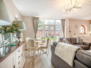 ein Wohnzimmer mit einem Sofa und einem Tisch in der Unterkunft Norfolk Cottages - The Ostlery in Smallburgh
