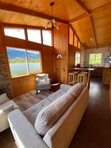 sala de estar con sofá grande y cocina en Turismo Vientos del Sur, en Mallin Grande