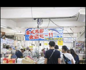 Un groupe de personnes marchant autour d'un magasin dans l'établissement They are NOT HOUSE - Vacation STAY 86998, à Okinawa