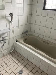 a bathroom with a green tub in a tiled room at They are NOT HOUSE - Vacation STAY 86998 in Okinawa City