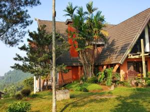 a house with a palm tree in front of it at Argapuri Jungle Resort Ciwidey in Ciwidey