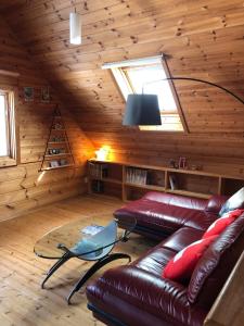 uma sala de estar com um sofá de couro e uma janela em Swiss Chalet - Vacation STAY 11450v em Iida