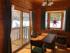 uma sala de jantar com uma mesa e uma grande janela em Swiss Chalet - Vacation STAY 11450v em Iida