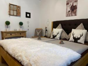1 dormitorio con 1 cama grande con manta blanca en Ferienwohnung Maringga, en Obermaiselstein