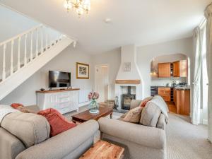 a living room with two couches and a table at Norfolk Cottages - The Coach House in Smallburgh