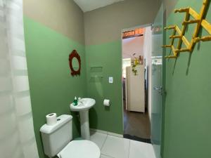 y baño con aseo blanco y lavamanos. en Sambála, en Itacaré