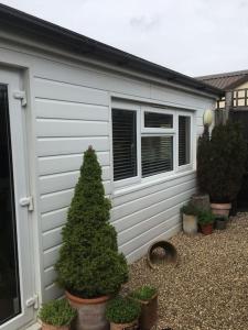 a christmas tree sitting in front of a garage at Herb Garden Bungalow in Nazeing