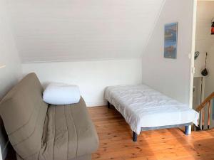 een kleine kamer met een bed en een bank bij Maison Trégastel, 2 pièces, 4 personnes - FR-1-368-26 in Trégastel