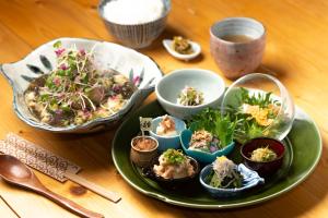 un plato de comida en una mesa con tazones de comida en 猿とモルターレ, en Kishiwada