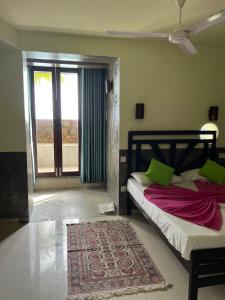 a bedroom with a bed and a window and a rug at La Veranda Di Serena in Unawatuna