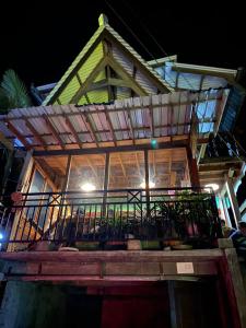 a house with a balcony on top of it at night at Smiley's Homestay in Berastagi