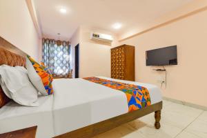 FabHotel JBS Heritage في جايبور: غرفة نوم مع سرير وتلفزيون بشاشة مسطحة