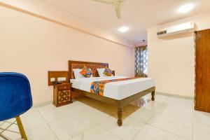 FabHotel JBS Heritage في جايبور: غرفة نوم بها سرير وكرسي أزرق