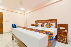 FabHotel JBS Heritage في جايبور: غرفة نوم مع سرير أبيض كبير وخزانة خشبية