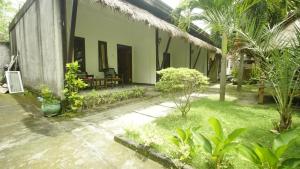 a courtyard of a house with chairs and plants at mimi kuta homestay in Kuta Lombok