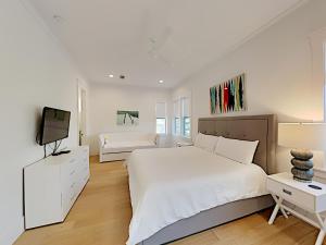een witte slaapkamer met 2 bedden en een televisie bij Destination Paradise in Destin