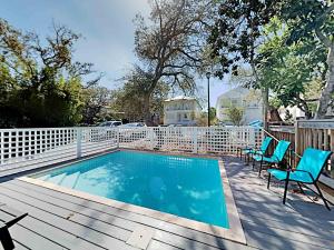 een zwembad op een terras met stoelen en een hek bij Destination Paradise in Destin