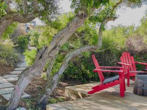 two red chairs sitting next to a tree at Rooisee in Yzerfontein