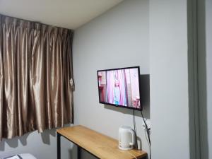 einen Flachbild-TV an der Wand in einem Zimmer in der Unterkunft Haising Hotel in Singapur