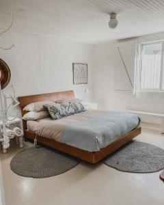 a bedroom with a bed with two rugs in it at Rooisee in Yzerfontein