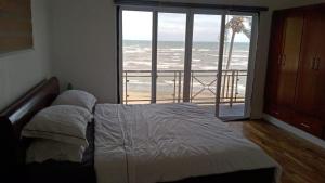 a bedroom with a bed and a view of the ocean at Nahas Beach Resort 